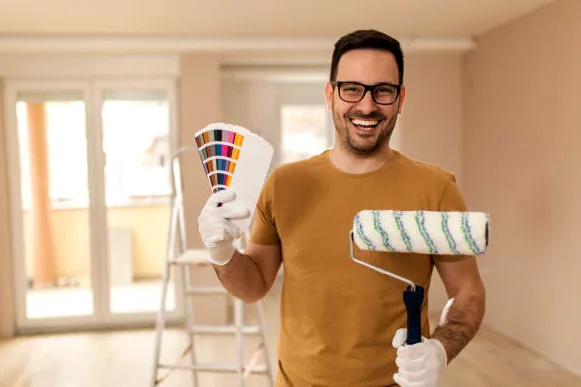 Charlotte painter holding a roller and color deck