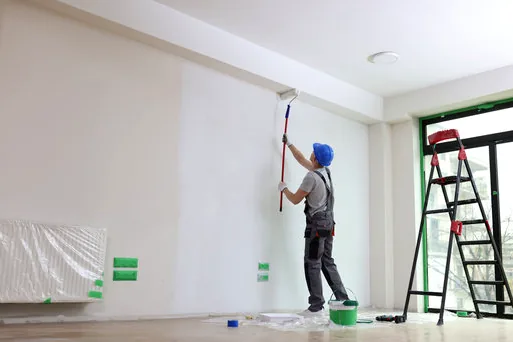Painter rolling a bright white office wall near University Research Park